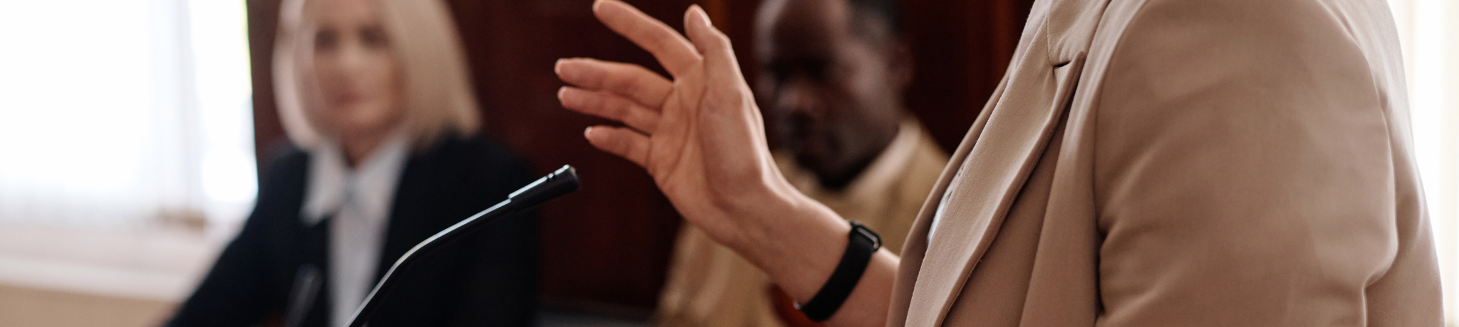 Woman testifying at lectern during a tribunal